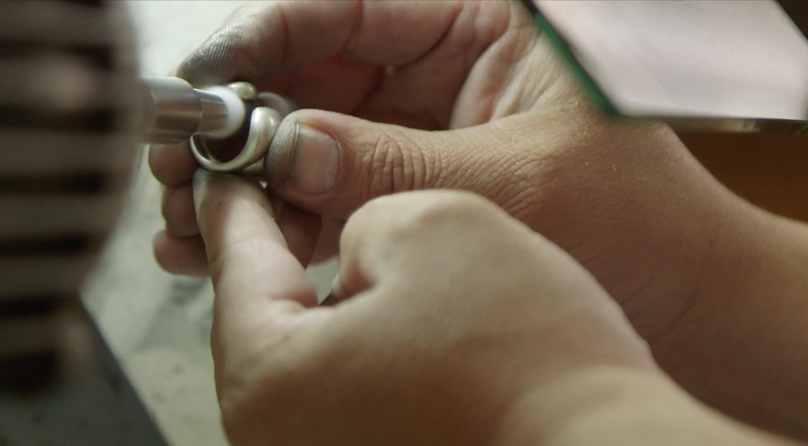 artisan hands working on a ring made out os recycled silver from x-rays