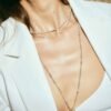 juana del rio modeling a white blazer and crop top and 3 silver chains with two hanging cone shapes pendants in silver and gold, colombian brand invited to aysha bilgrami jewelry pop up shop in bogota colombia