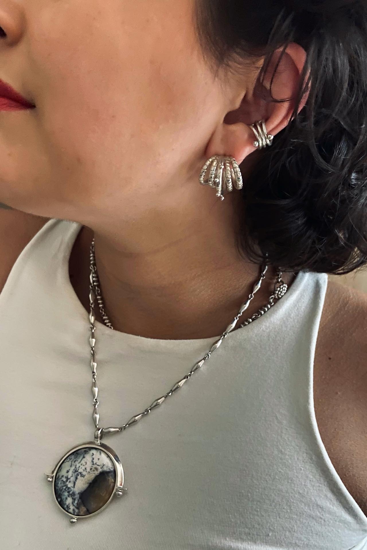 girl wearing silver jewelry, five moon hoops, chain with full moon turkish opal pendant and ear cuff. By aysha bilgrami made in colombia in recycled silver