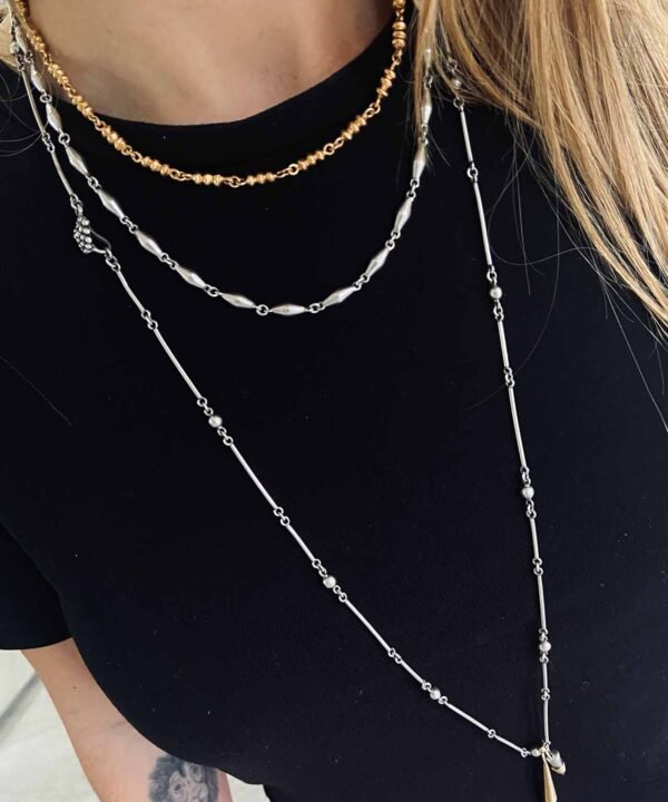 girl wearing black t shirt with silver and gold chains by aysha bilgrami.